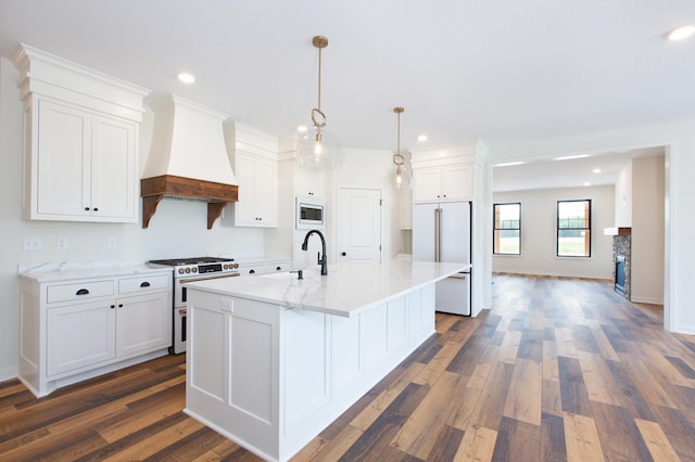 kitchen featuring dark hardwood / wood-style floors, an island with sink, pendant lighting, high end appliances, and custom exhaust hood