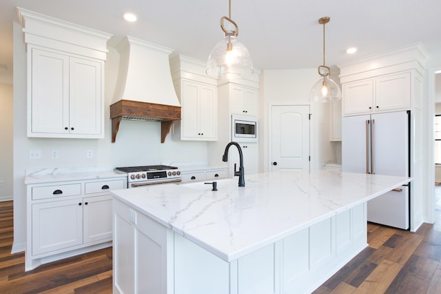 kitchen with custom range hood and a kitchen island with sink