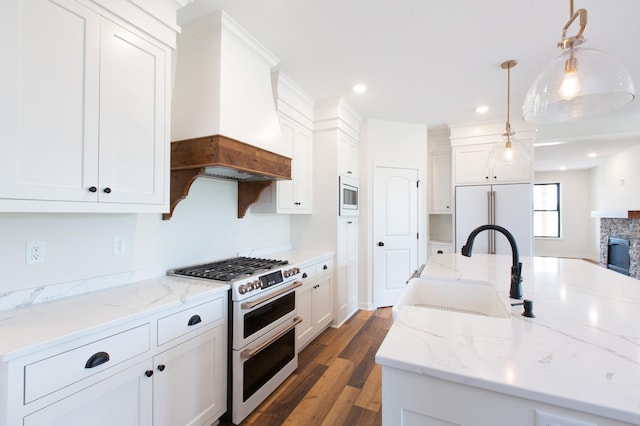 kitchen with white cabinetry, hanging light fixtures, dark hardwood / wood-style floors, premium range hood, and high quality appliances