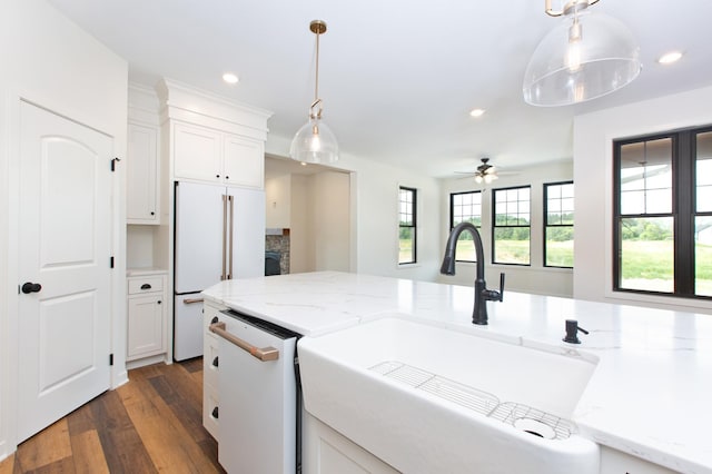 kitchen with dark wood-type flooring, ceiling fan, decorative light fixtures, white dishwasher, and white cabinets