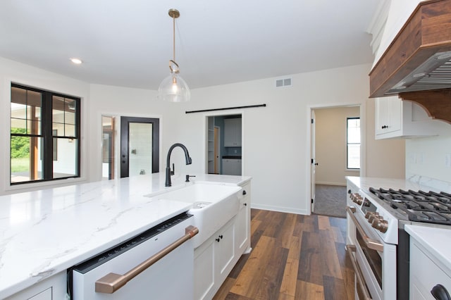 kitchen featuring premium range hood, decorative light fixtures, double oven range, dishwashing machine, and white cabinets