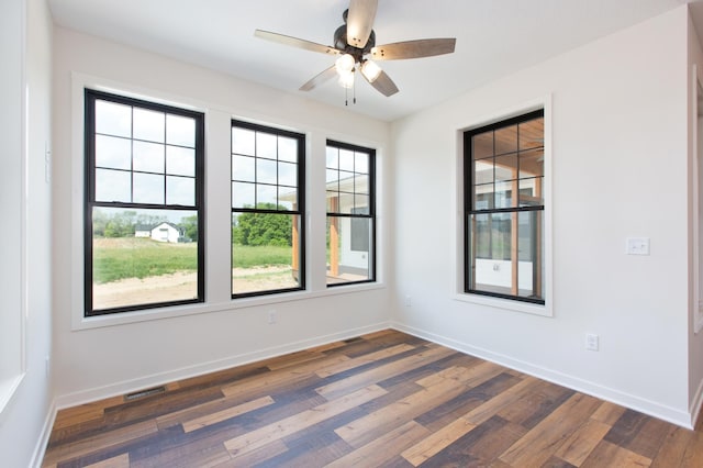 empty room with ceiling fan and dark hardwood / wood-style floors