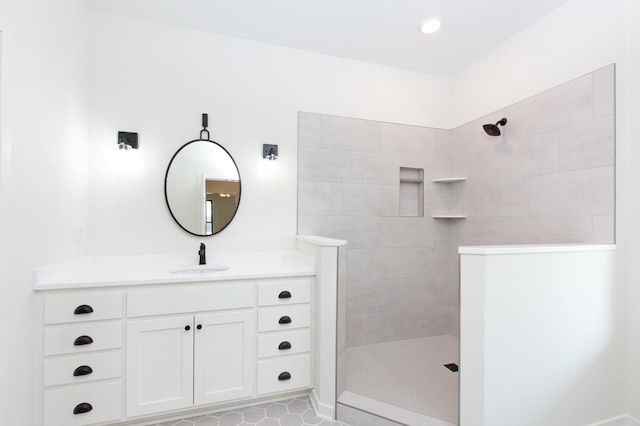 bathroom with tile floors, tiled shower, and vanity