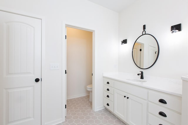 bathroom featuring toilet, large vanity, and tile floors