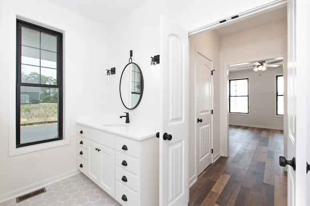 bathroom featuring ceiling fan, large vanity, and hardwood / wood-style flooring