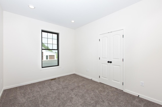 spare room with dark carpet