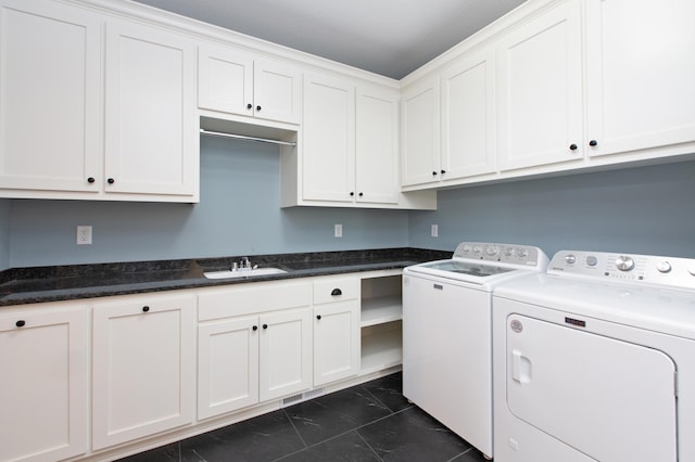 washroom featuring washer and clothes dryer, dark tile floors, cabinets, and sink