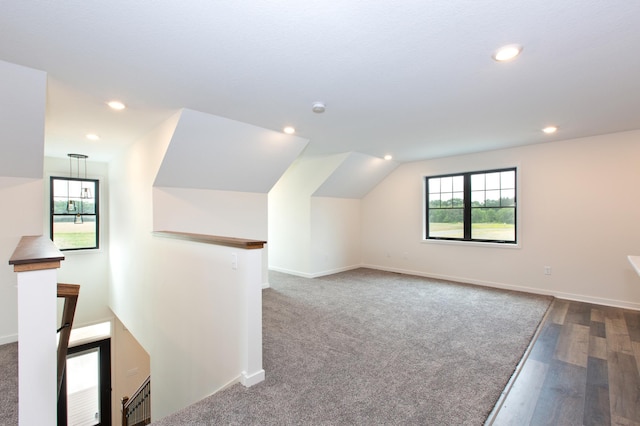 additional living space featuring dark hardwood / wood-style flooring and vaulted ceiling