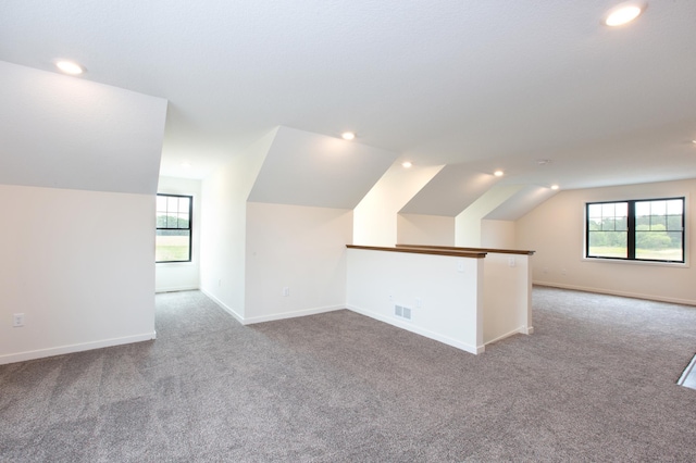 bonus room featuring lofted ceiling and light carpet