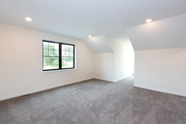 additional living space featuring lofted ceiling and carpet flooring