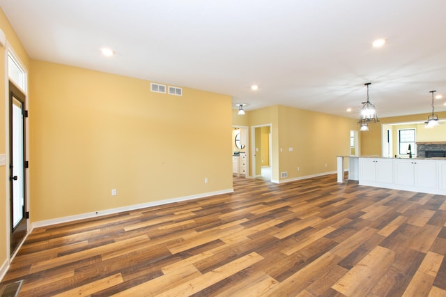 unfurnished living room featuring wood-type flooring and sink