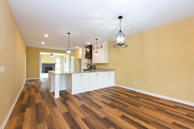 kitchen featuring white cabinets, pendant lighting, dark wood-type flooring, and kitchen peninsula