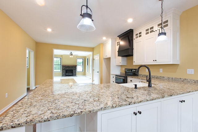 kitchen with hanging light fixtures, ceiling fan, custom exhaust hood, black electric range, and white cabinets