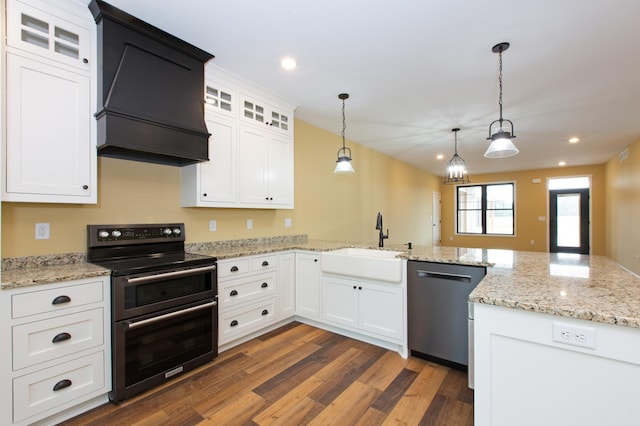 kitchen with decorative light fixtures, white cabinetry, stainless steel dishwasher, range with two ovens, and sink