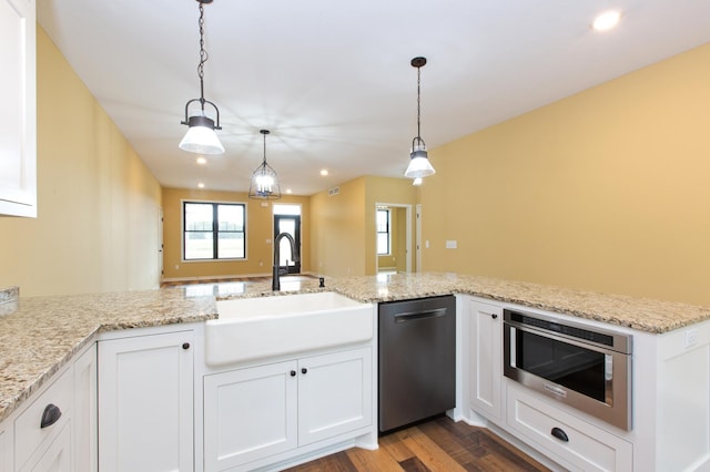 kitchen featuring stainless steel dishwasher, decorative light fixtures, dark hardwood / wood-style flooring, sink, and white cabinets