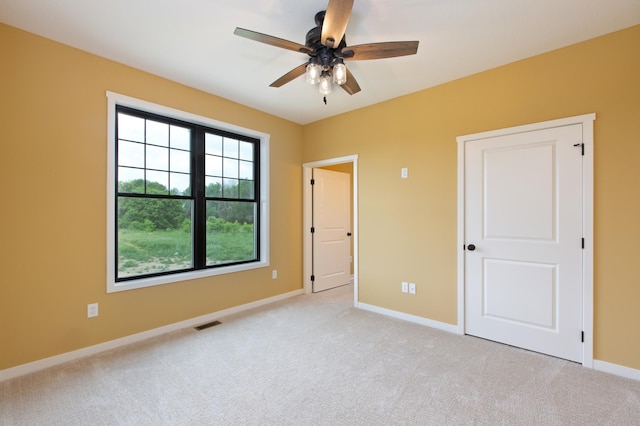 interior space with ceiling fan and light carpet