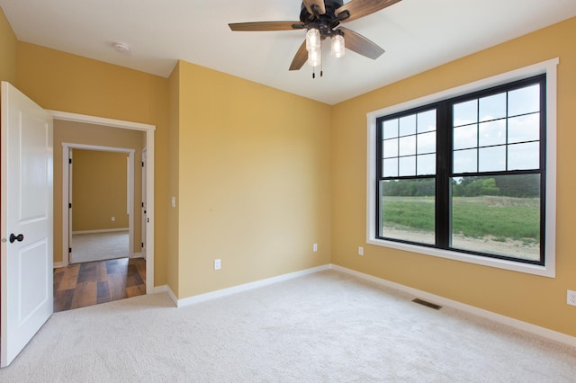 empty room featuring plenty of natural light, ceiling fan, and light wood-type flooring