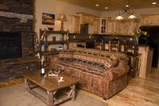 living room featuring light hardwood / wood-style floors, a fireplace, and a chandelier