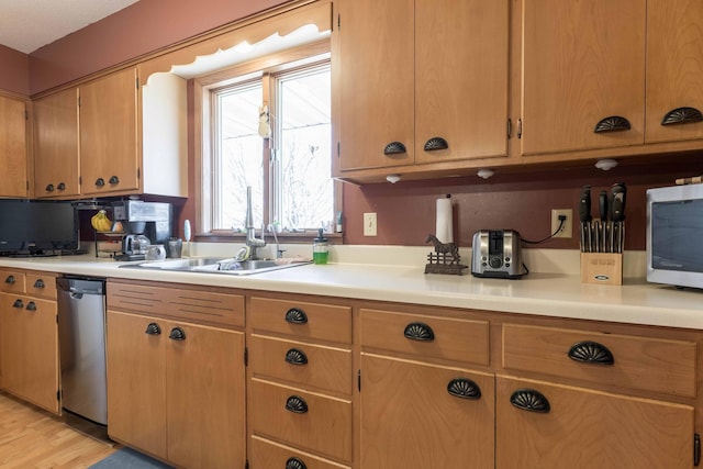 kitchen with stainless steel appliances, light hardwood / wood-style floors, and sink