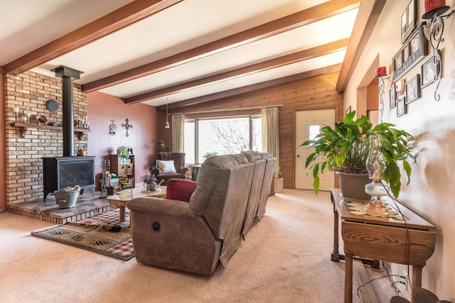 carpeted living room with vaulted ceiling with beams and a wood stove