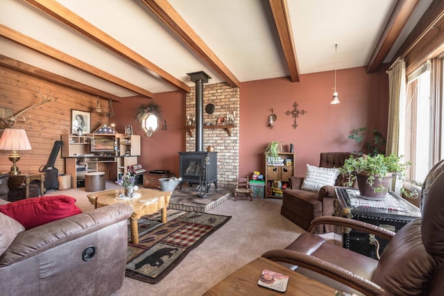 carpeted living room with beamed ceiling, a wood stove, and wood walls