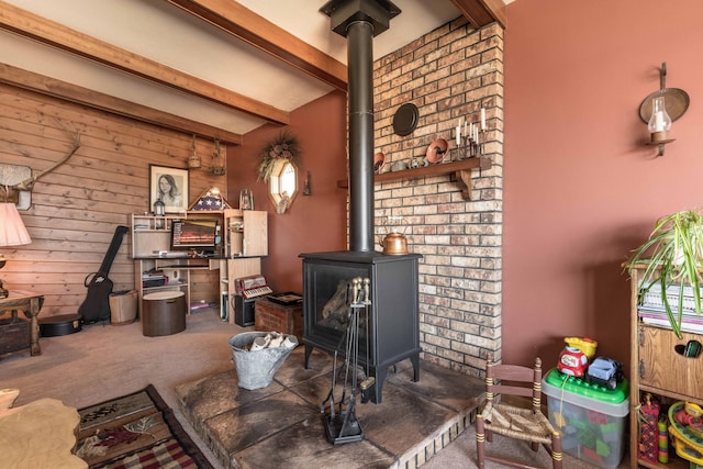 carpeted living room with a wood stove and beamed ceiling