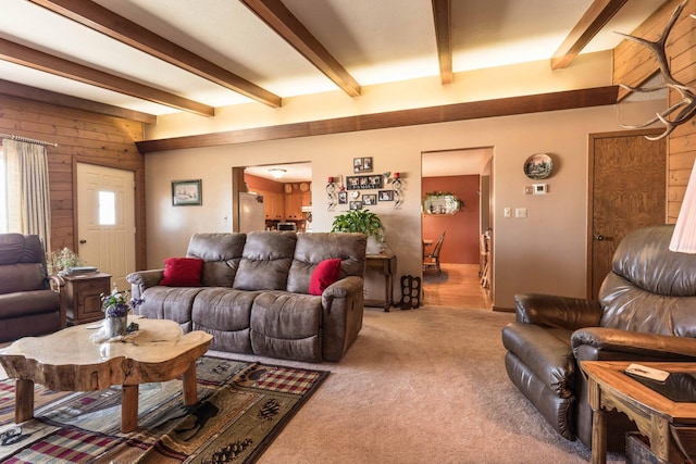 living room with light carpet, beamed ceiling, and wood walls