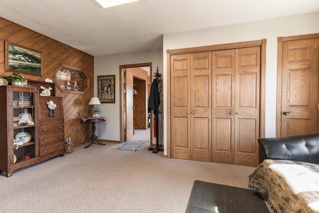 carpeted bedroom featuring wooden walls