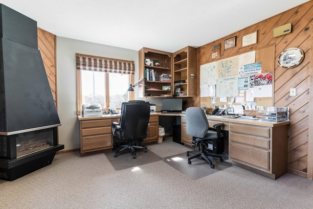 carpeted home office with wood walls