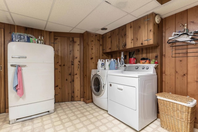 washroom featuring wood walls and separate washer and dryer