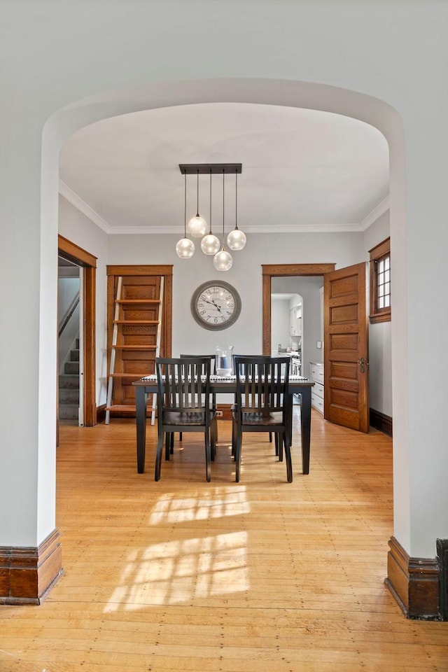 dining area featuring ornamental molding, a chandelier, and light hardwood / wood-style floors