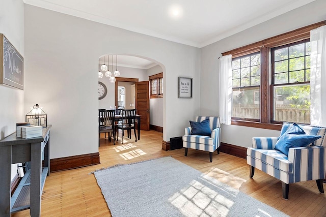 sitting room with crown molding and light wood-type flooring