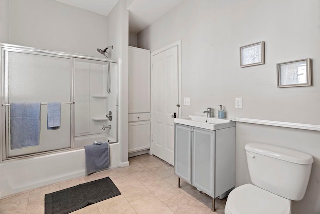 full bathroom with tile floors, toilet, vanity, and combined bath / shower with glass door