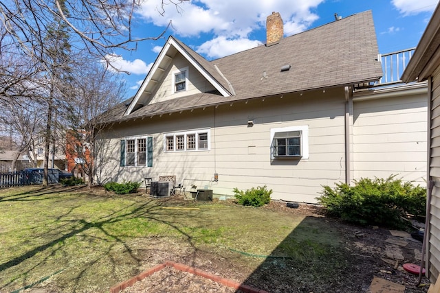 back of property featuring central AC unit and a lawn