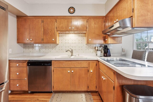 kitchen featuring fume extractor, dishwasher, black electric cooktop, and light hardwood / wood-style flooring