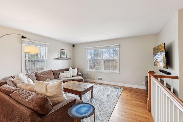 living room featuring a healthy amount of sunlight and light hardwood / wood-style flooring