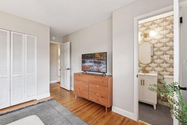 bedroom with light hardwood / wood-style floors and a closet