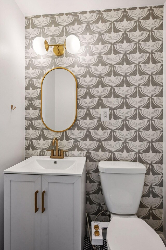 bathroom featuring vanity with extensive cabinet space and toilet