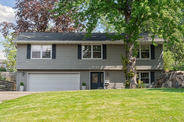 bi-level home with a garage and a front lawn