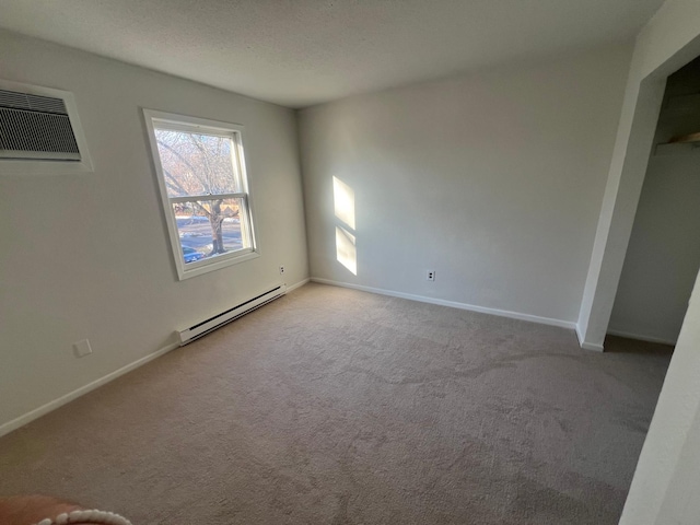 carpeted spare room with a wall unit AC and a baseboard radiator