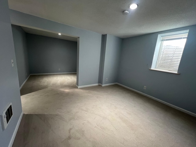 basement with a textured ceiling and carpet floors