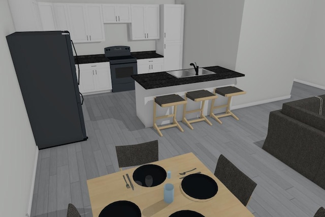 kitchen with black appliances, sink, a breakfast bar, white cabinets, and light hardwood / wood-style flooring