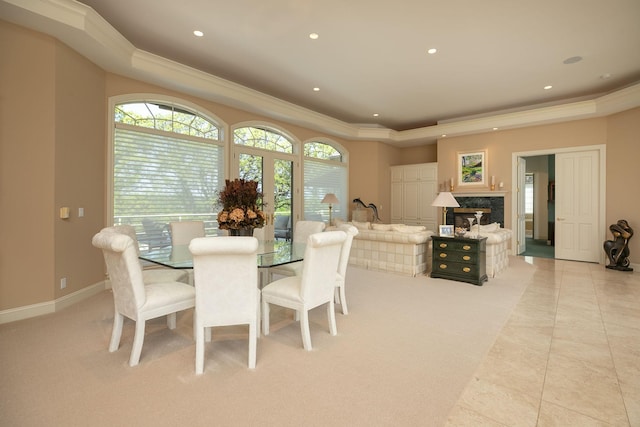 tiled dining area with a fireplace and crown molding