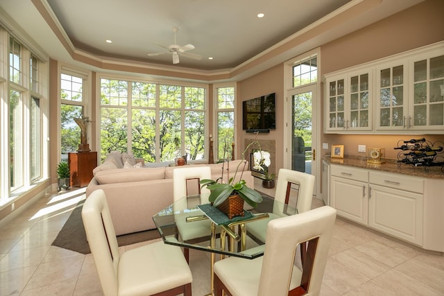 tiled dining area featuring ceiling fan and crown molding