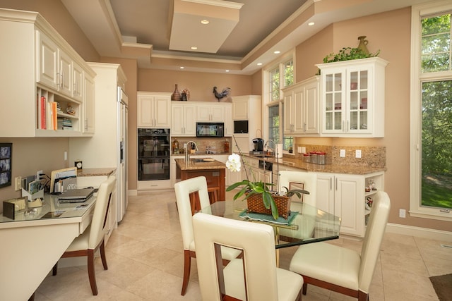 kitchen featuring white cabinetry, light stone countertops, light tile patterned flooring, and black appliances