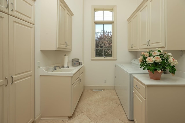 laundry area featuring washer and clothes dryer, light tile patterned floors, cabinets, and sink