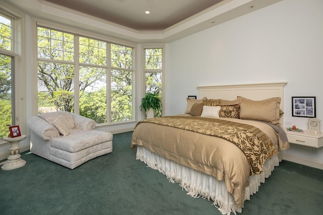 carpeted bedroom featuring a tray ceiling, multiple windows, and ornamental molding