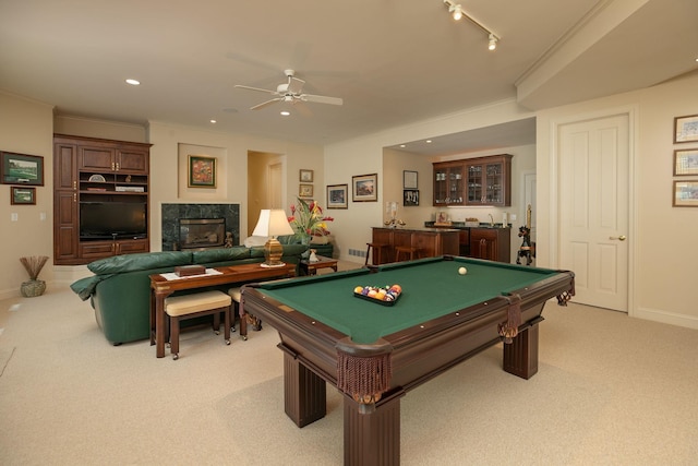 rec room with a high end fireplace, light colored carpet, ceiling fan, crown molding, and billiards