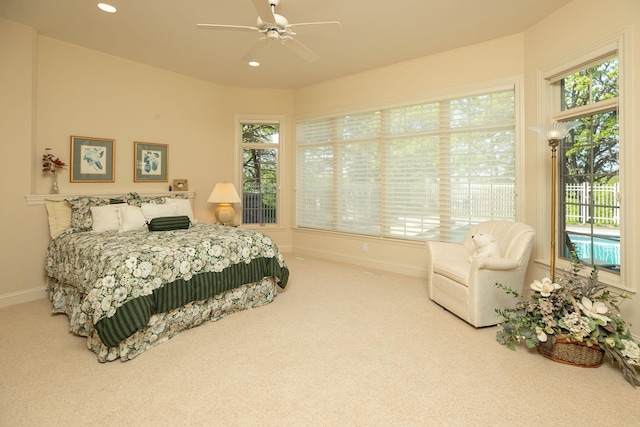 bedroom featuring ceiling fan, carpet floors, and multiple windows