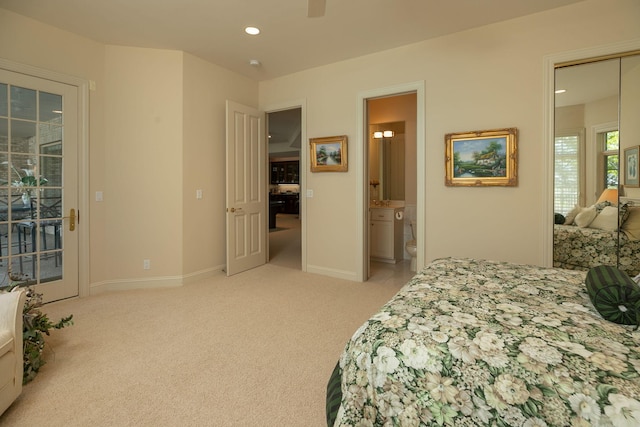 bedroom with ensuite bath, ceiling fan, light colored carpet, and access to exterior